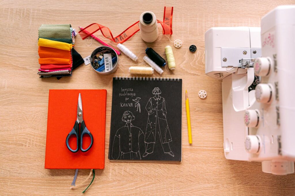 Top view of a sewing workspace featuring a sewing machine, tools, and fashion sketches on a wooden surface.